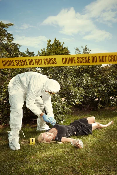 Técnico trabajando en la recolección de evidencias sobre el cuerpo de la víctima — Foto de Stock