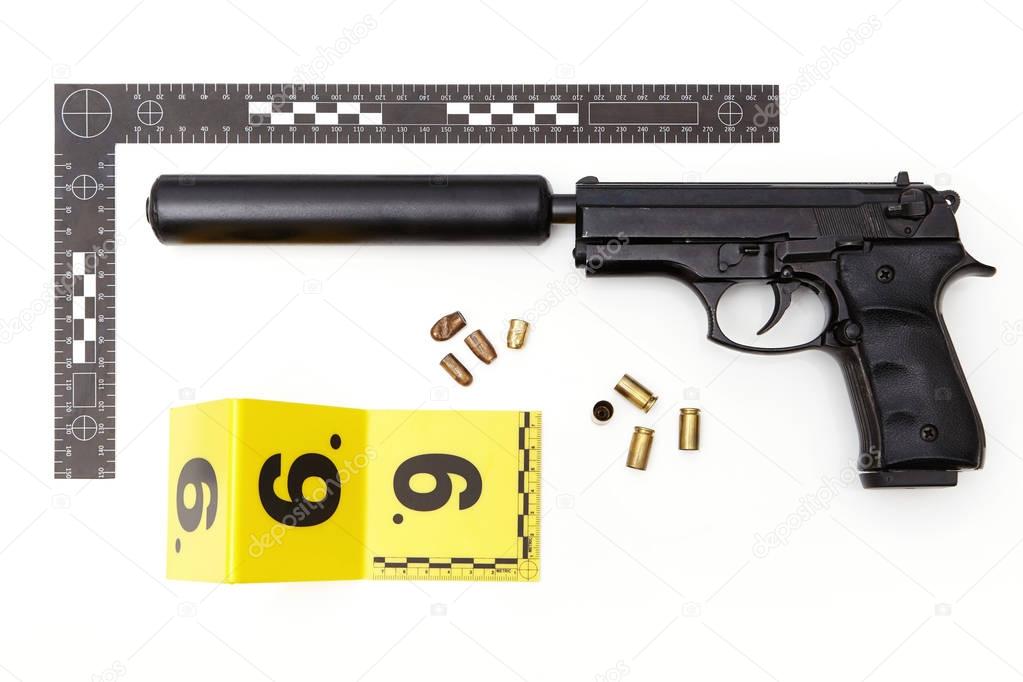 Evidence photography of handgun with mounted silencer and ammunition
