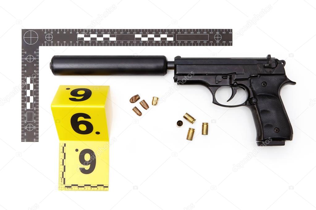 Evidence photography of handgun with mounted silencer and ammunition