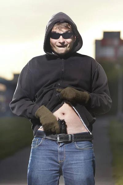 Hombre común con gafas de sol mostrando su pistola detrás de la cintura — Foto de Stock