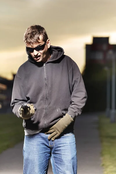Helpless man with pistol in hands on public place — Stock Photo, Image