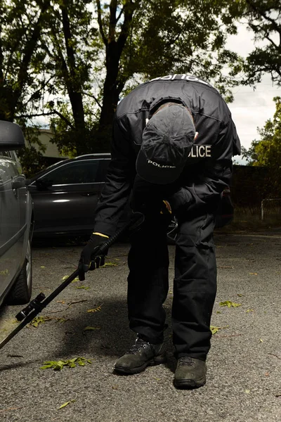 Politie man auto voor mogelijk explosief controleren — Stockfoto