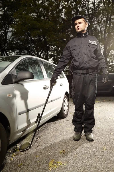 Polizist überprüft Auto auf möglichen Sprengsatz — Stockfoto