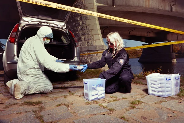 Policejní tým balíčky zabavených drog v kufru auta na kontejnery — Stock fotografie