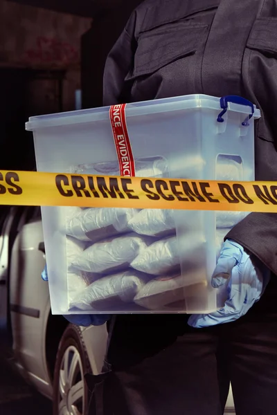 L'agente di polizia tiene la droga sequestrata trovata nel bagagliaio dell'auto — Foto Stock