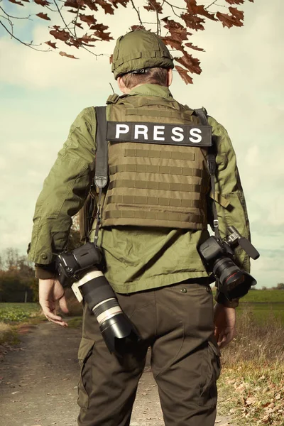 Военный фотограф в поле пешком — стоковое фото