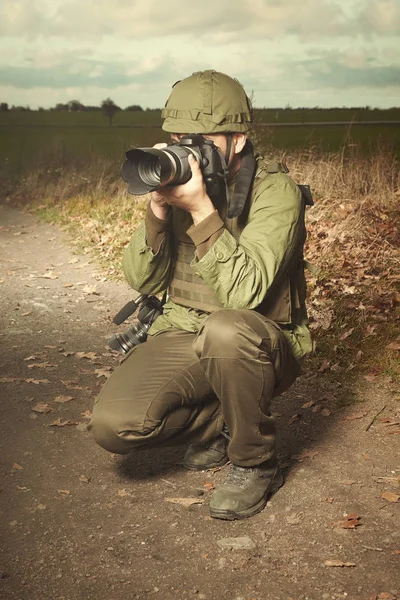 Fotógrafo de guerra en el campo haciendo su peligroso trabajo — Foto de Stock