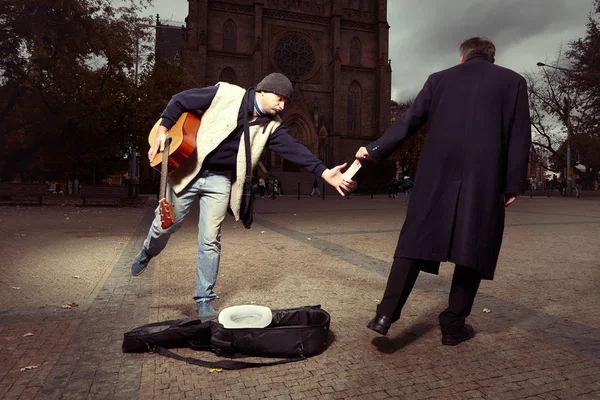 Nieznany mężczyzna kradzież pieniędzy do żebraka z gitara — Zdjęcie stockowe