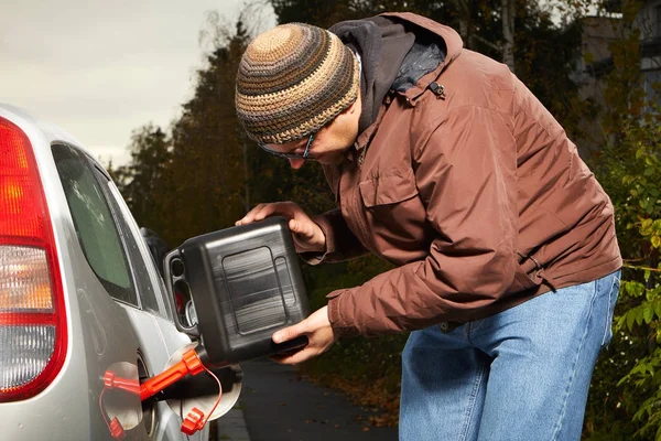 Homem no vestido de inverno enchendo tanque de carro de plástico — Fotografia de Stock