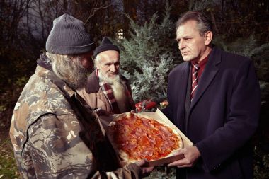 Man in suit met two homeless men in winter park and ordering pizza clipart