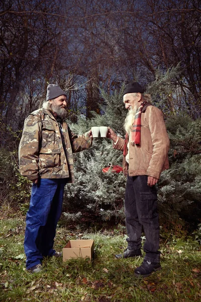 Two homeless men celebrating christmas alone in park — Stock Photo, Image