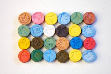 Several pills of MDMA (Extasy) on white table distributed by drug dealer clipart