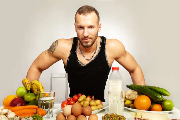 Muscle fitness man with his healthy food menu on plates