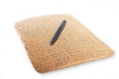 Ancient type of Akkad empire style cuneiform writing in brown clay with rest of dirty sand and writing tool clipart