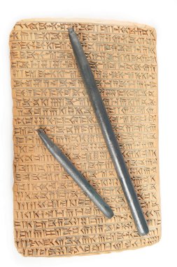 Ancient type of Akkad empire style cuneiform writing in brown clay with rest of dirty sand and writing tools clipart
