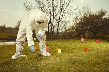 Kriminoloji uzmanı teknisyen Dna delilleri bayrakları ile arazide izlemeyi steril genel çalışma