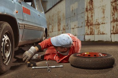 Kırmızılı yakışıklı adam eski güzel arabasını dinliyormuş.