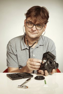 Bir doktor gibi dijital kamerayı tamir eden çılgın bir teknisyen.