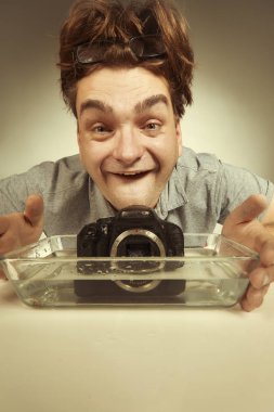 Çılgın teknisyen dijital kamerayı suda kötü şekilde temizliyor.