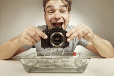 Çılgın teknisyen dijital kamerayı suda kötü şekilde temizliyor.