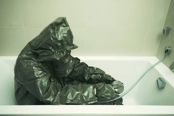 Ugly man in bathroom dressed to protective suit and mask showering