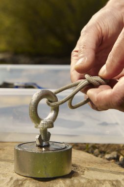 Preparing of neodymium magnet of rope for exploring water clipart