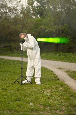 Koruyucu giysili kriminolog teknisyen balistik lazerle çalışıyor.