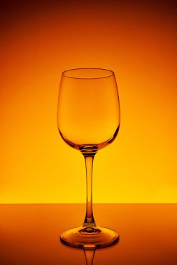 Sarı-turuncu zemin üzerinde bir şarap kadehi.