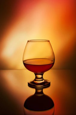 Alevlerin arkasında bir bardak viski.