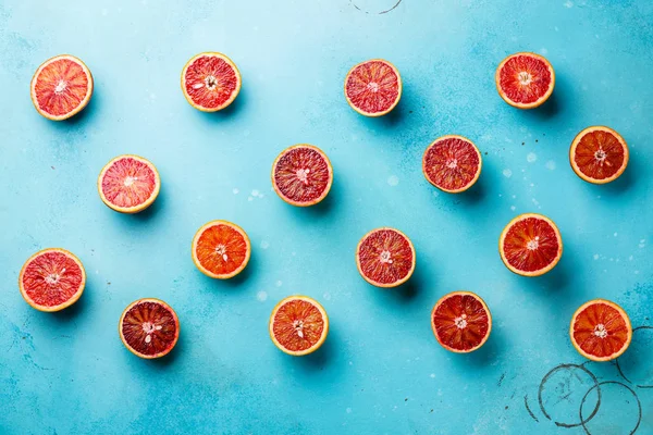 Citrus fruit pattern of fresh red orange slices on blue background