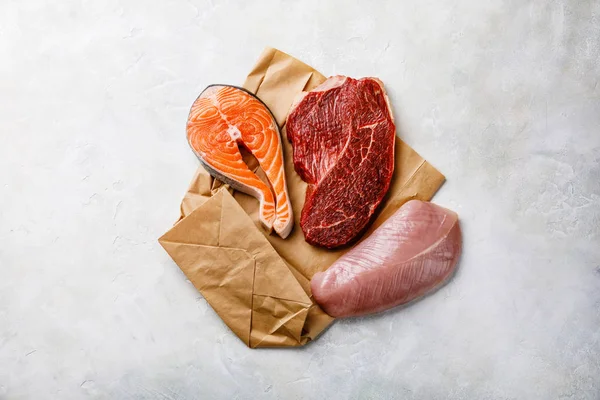 Raw food Salmon oily fish steak, beef meat and turkey breast on white textured background — Stock Image Raw Food Salmon Oily Fish Steak Beef Meat Turkey Breast Royalty Free Stock Photos
