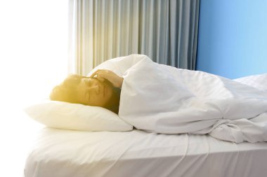 adam yatakta uyku ve bir akıllı telefon tutan