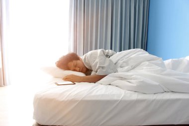 adam yatakta ve bir akıllı telefon uyku