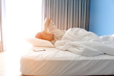 adam yatakta ve bir akıllı telefon uyku