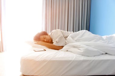 adam yatakta ve bir akıllı telefon uyku