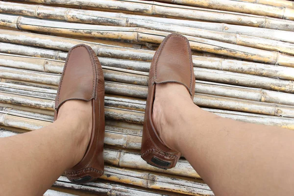 Kahverengi ayakkabı bambu ahşap arka plan üzerinde