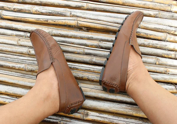 Kahverengi ayakkabı bambu ahşap arka plan üzerinde