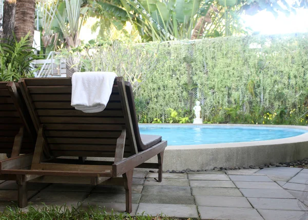 Plaj sandalyeleri yakınındaki yüzme havuzu havlu ile