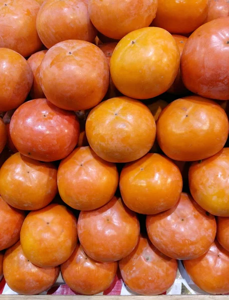 Organic persimmon fruits in pile at local farmers market