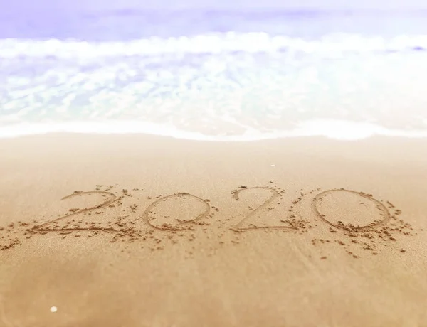 Happy new year , lettering numbers 2020 year on the sand