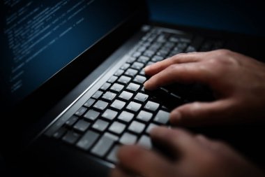 Programcı veya bilgisayar dizüstü klavyede yazarak hacker