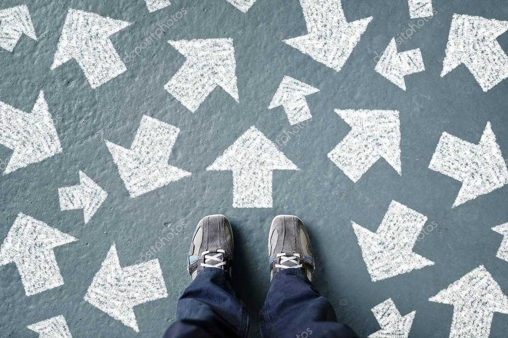 man standing with many direction arrows