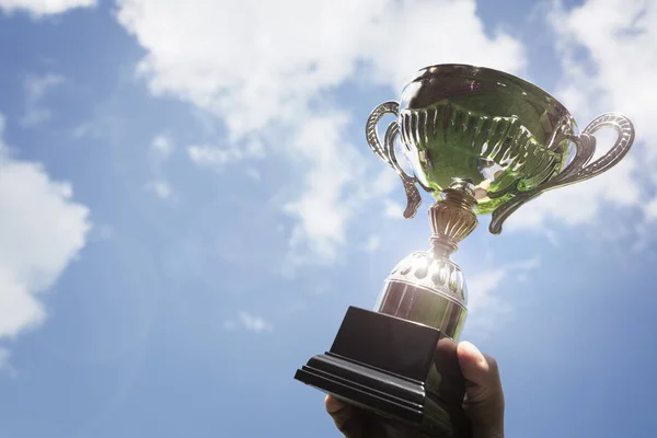 Holding up a trophy cup as a winner — Stock Photo, Image