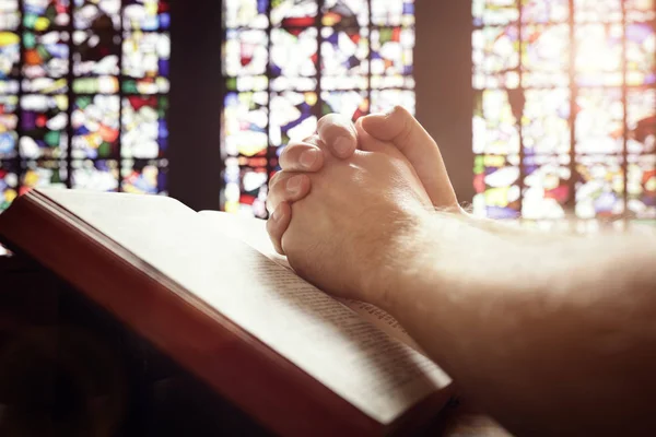 Orando mãos sobre uma Bíblia Sagrada — Fotografia de Stock