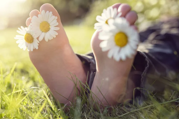 Bambino con margherita tra le dita dei piedi — Foto Stock