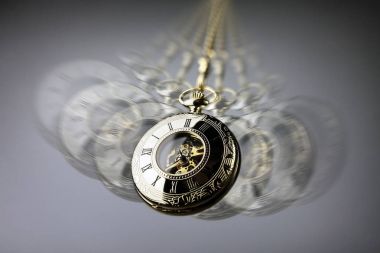 Hypnotism concept, gold pocket watch swinging used in hypnosis treatment clipart