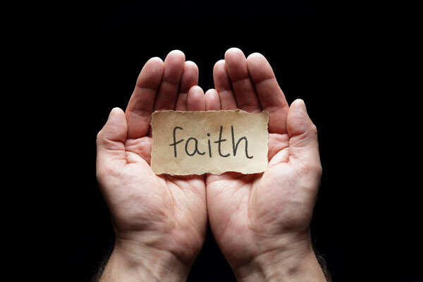 Faith message in cupped hands, concept for love, religion, belief and prayer