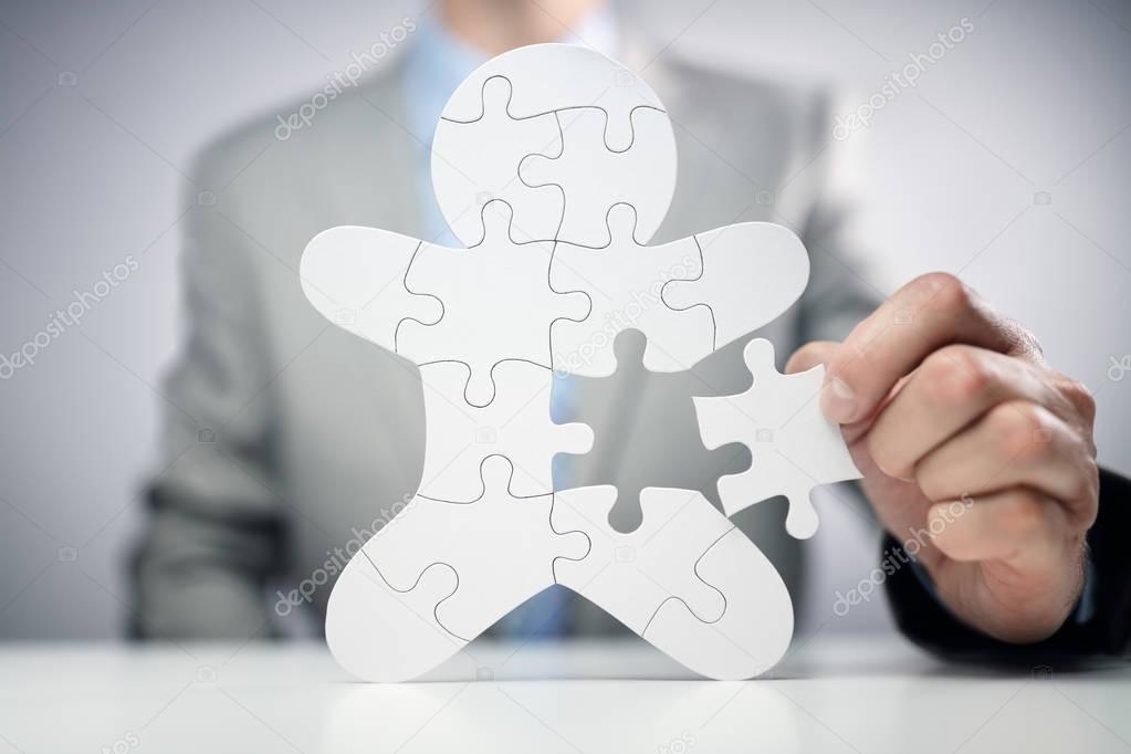 Businessman assembling jigsaw puzzle human team employee concept