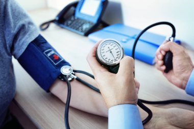 Doctor measuring blood pressure of patient clipart