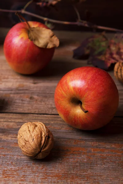 Äpfel und buntes Laub fallen auf alte rustikale Holzbretter. Herbst. Schöne Ernte Herbst Konzept. Herbstzusammensetzung — Stockfoto